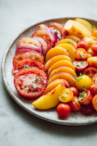 Add the peach slices evenly around the tomatoes.