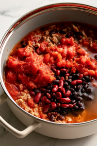 Pour in the crushed tomatoes, diced tomatoes
